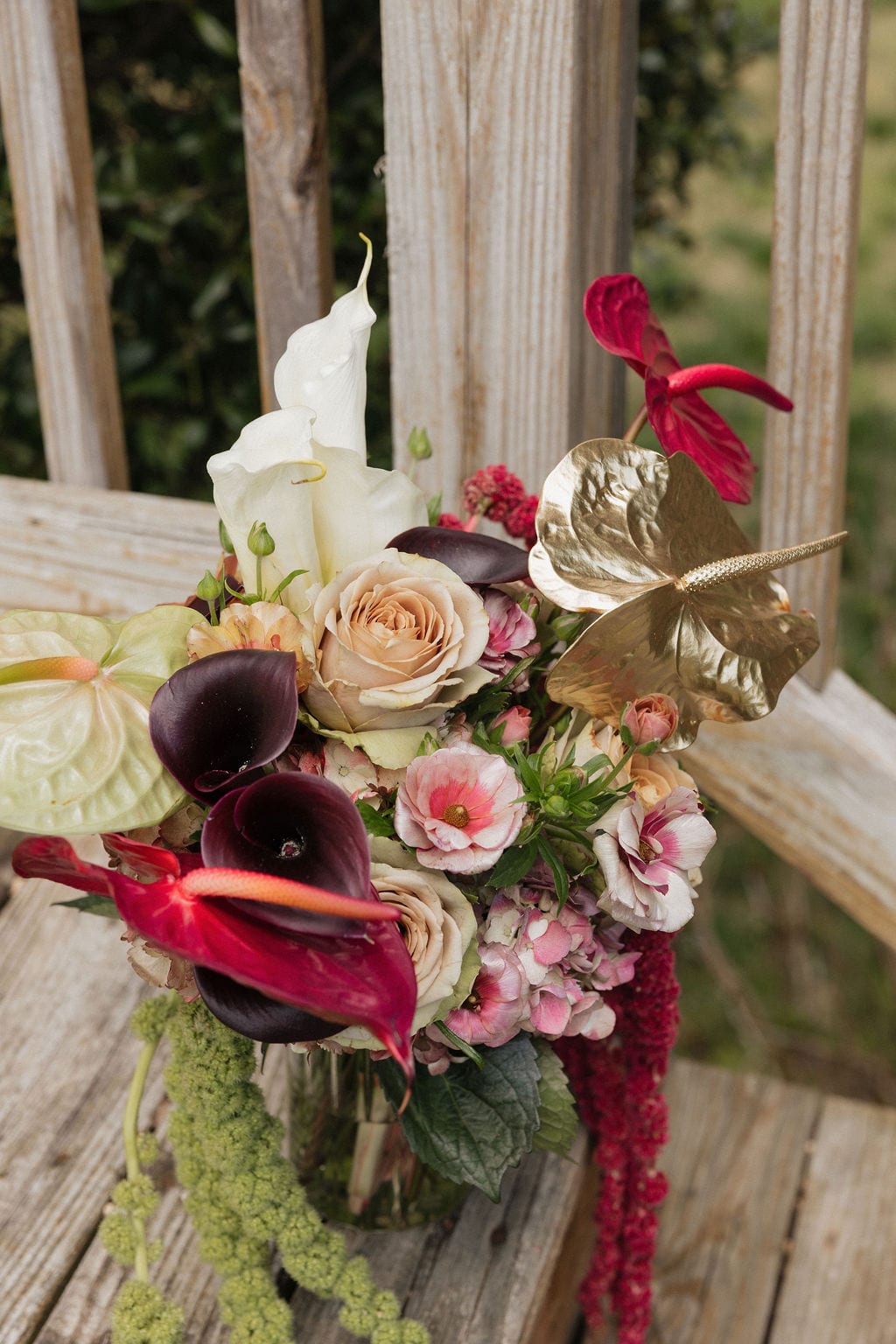 Bridal bouquet close-up with gold anthurium and dark calla lilies at the Callie & Jeremy wedding — designed by Lael Florals