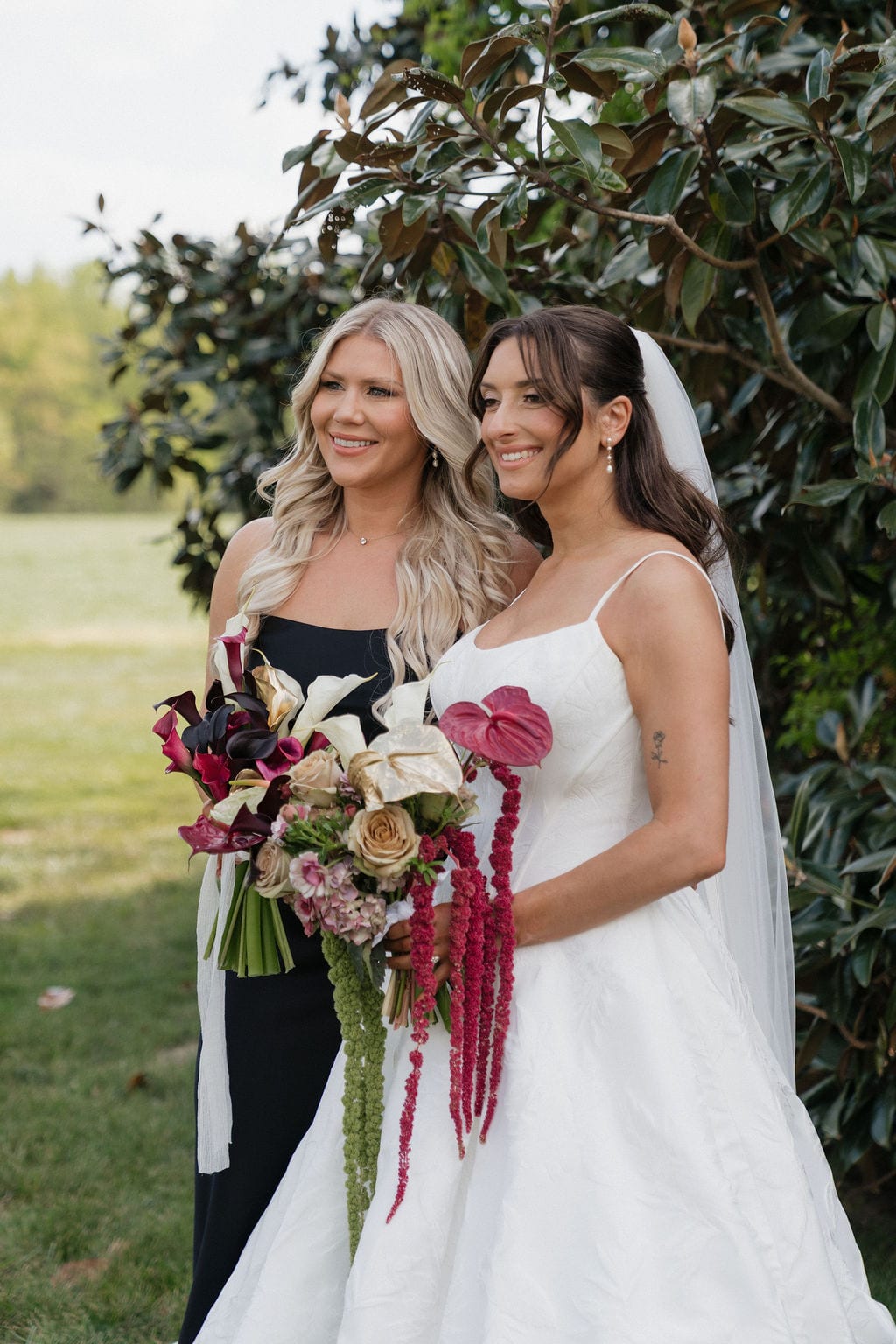 Bride and bridesmaid holding contrasting calla and anthurium bouquets at the Callie & Jeremy wedding — designed by Lael Florals