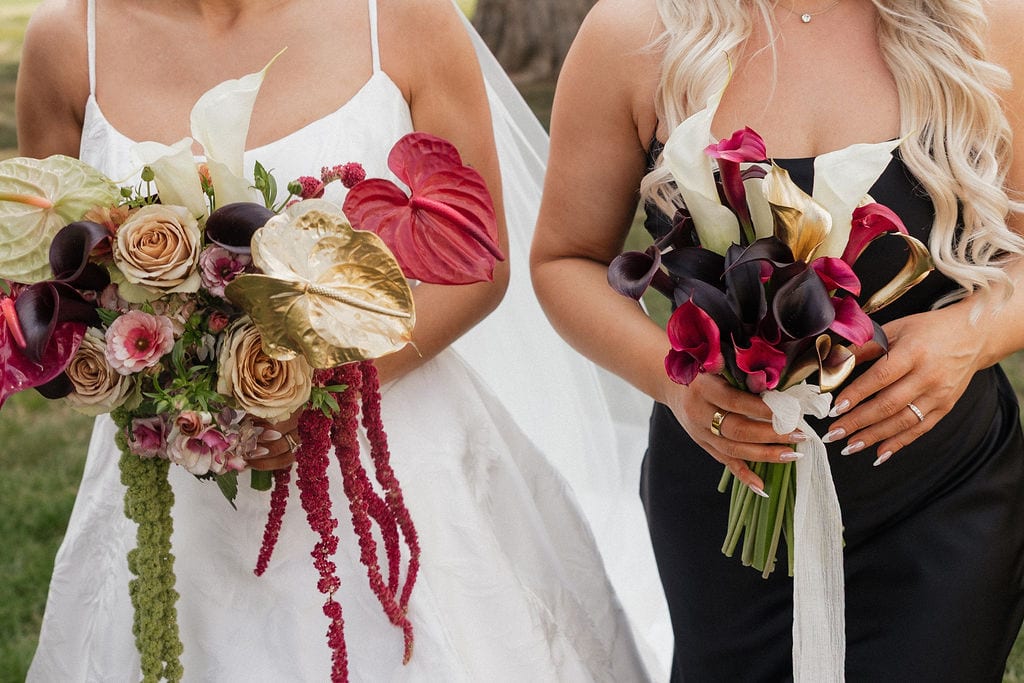 Close crop of bridal and bridesmaid bouquets with gold anthurium and dark callas at the Callie & Jeremy wedding — designed by Lael Florals