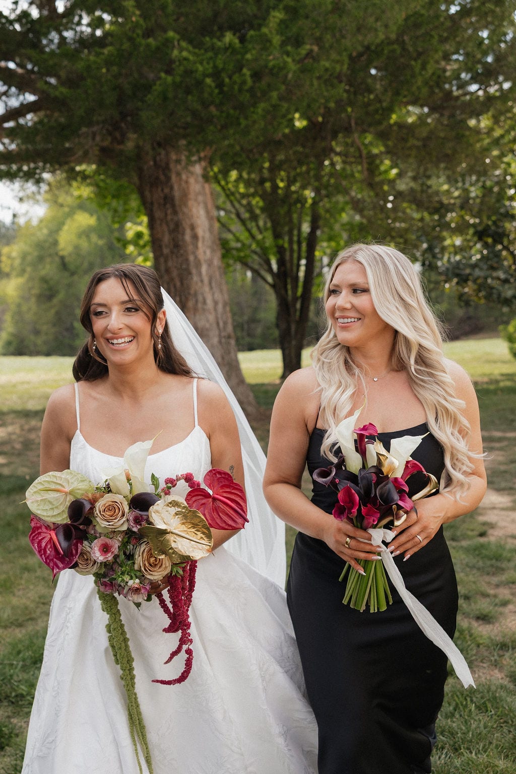 Bride and bridesmaid walking with calla and anthurium bouquets at the Callie & Jeremy wedding — designed by Lael Florals