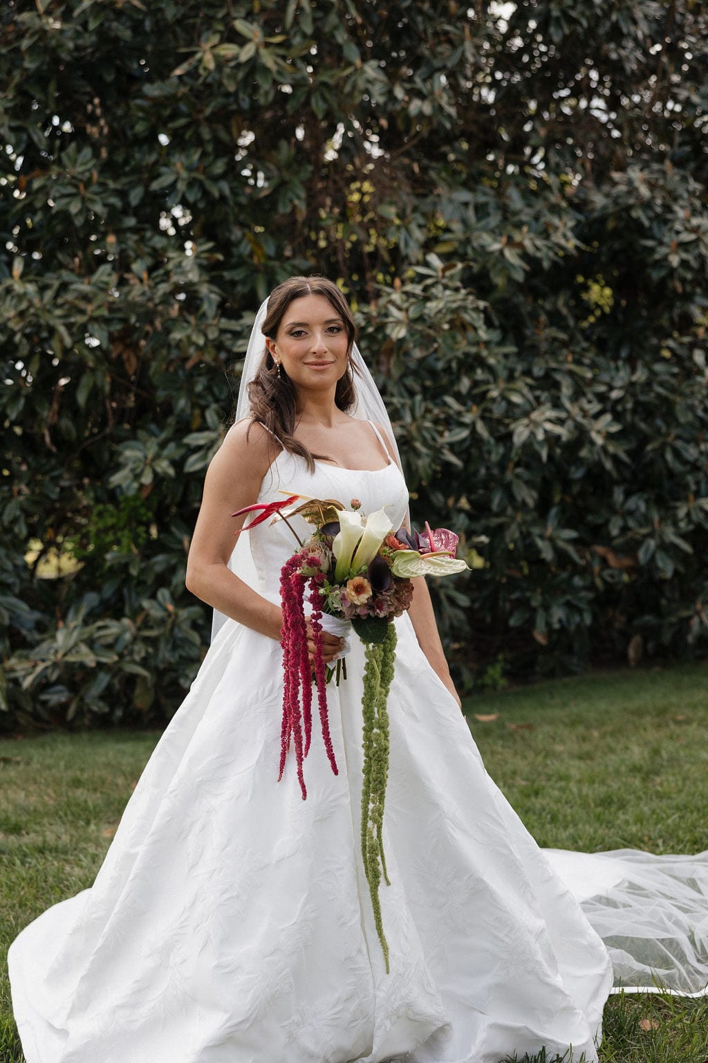 Bride with a cascading anthurium and amaranthus bouquet at the Callie & Jeremy wedding — designed by Lael Florals