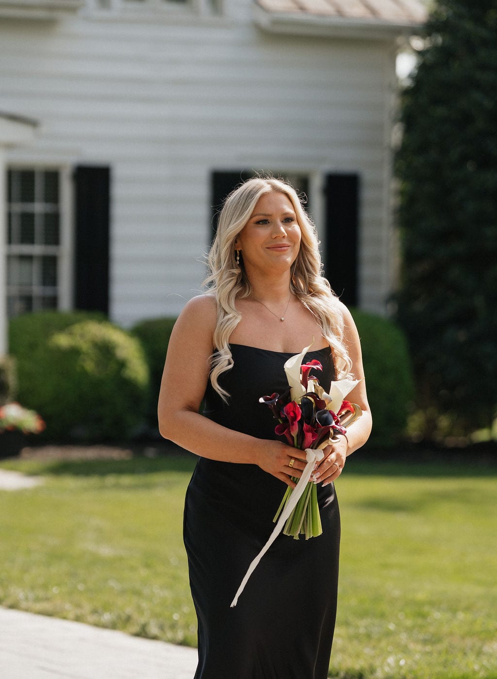 Bridesmaid holding a burgundy and white calla lily bouquet at the Callie & Jeremy wedding — designed by Lael Florals