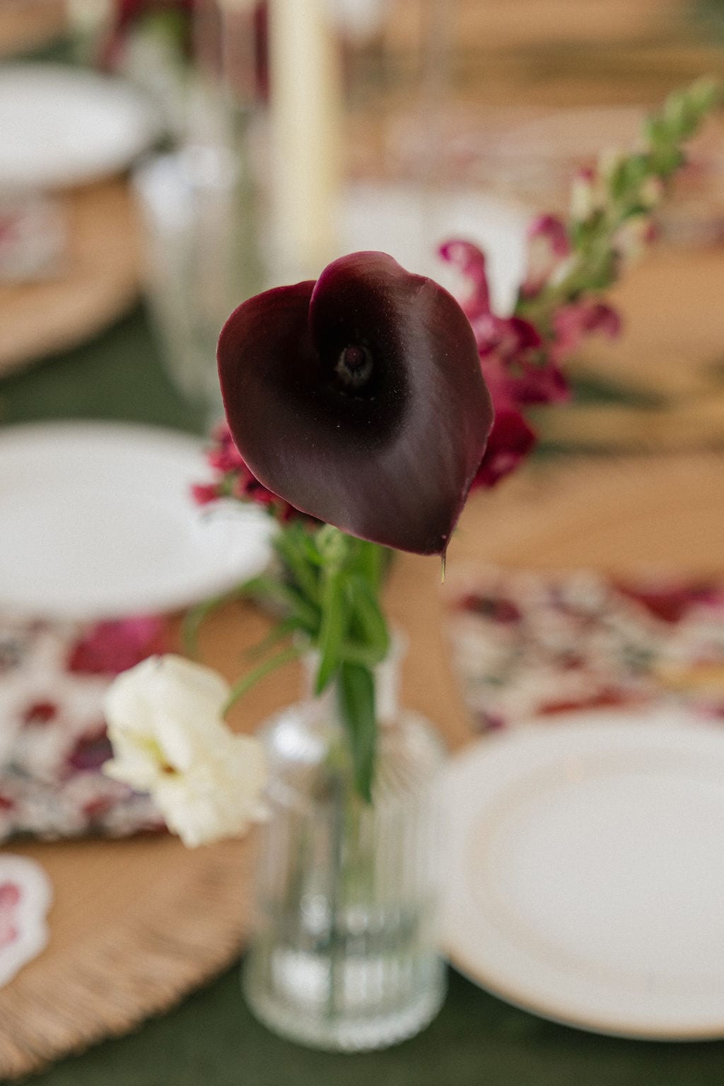 Deep burgundy calla lily in a crystal bud vase at the Callie & Jeremy wedding — designed by Lael Florals