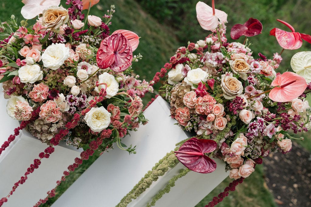 Overhead view of pedestal arrangements with trailing amaranthus at the Callie & Jeremy wedding — designed by Lael Florals