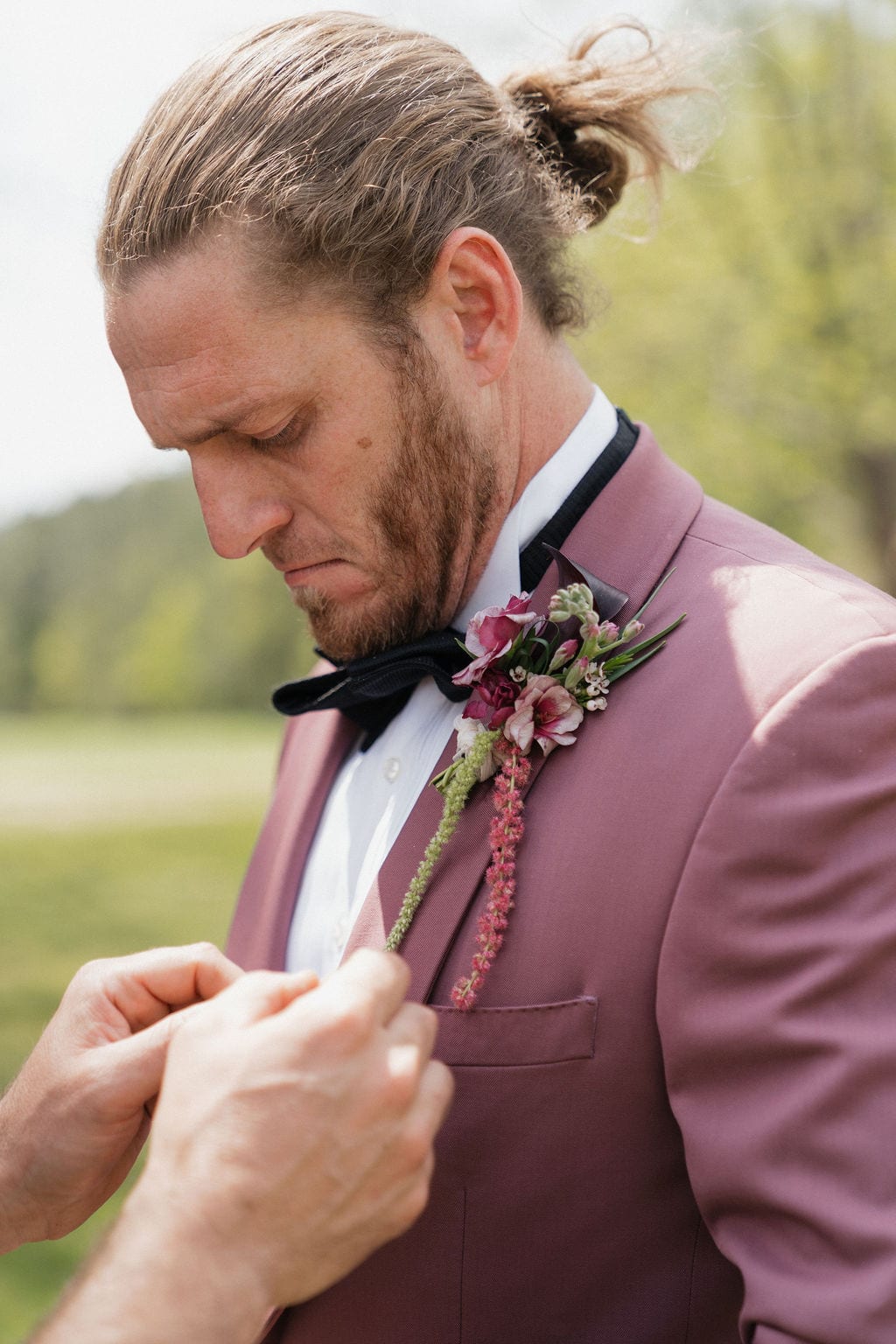 Trailing pink boutonniere pinned on the groom's mauve lapel at the Callie & Jeremy wedding — designed by Lael Florals