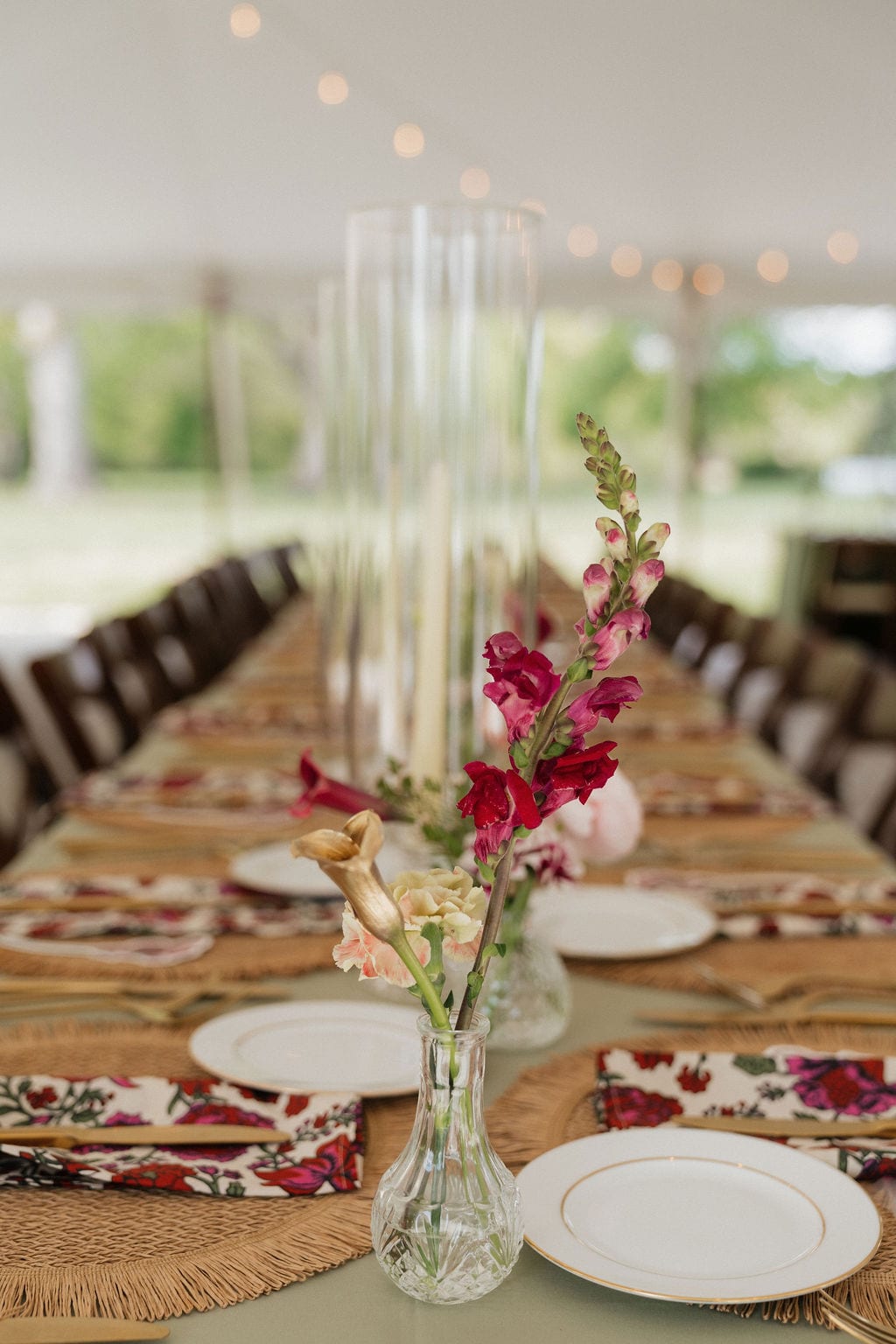 Snapdragon and calla bud vase down a tented long table at the Callie & Jeremy wedding — designed by Lael Florals