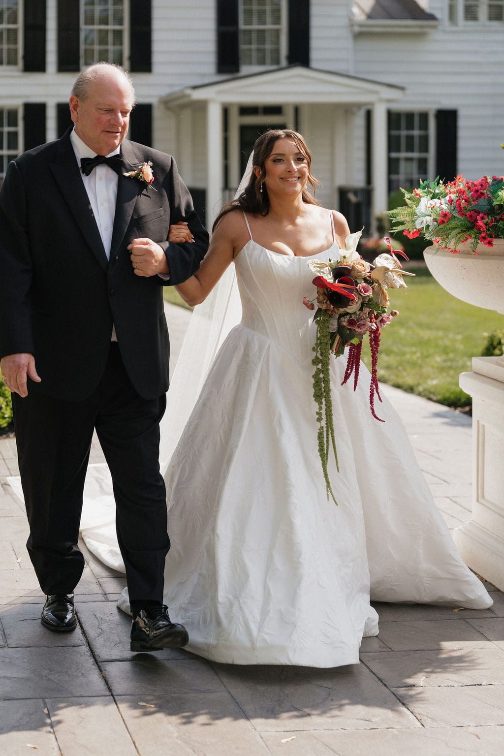Bride carrying a cascading bouquet down the aisle at the Callie & Jeremy wedding — designed by Lael Florals