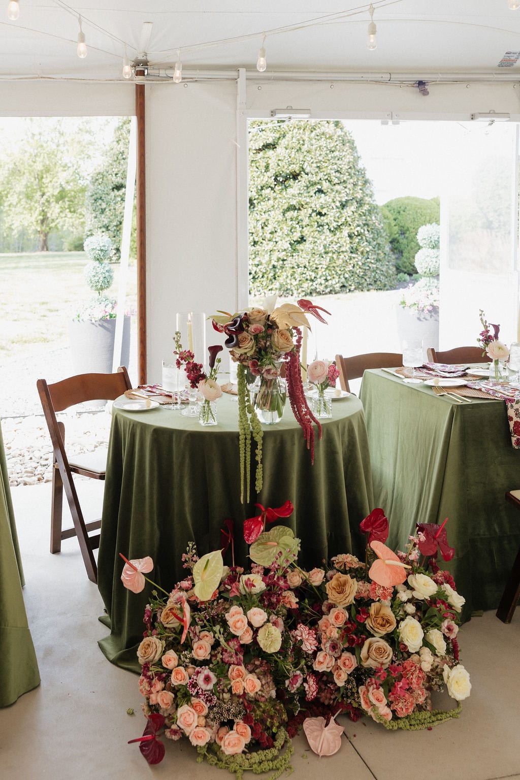 Tented reception with green velvet tablescapes and meadow-style floral installation at the Callie & Jeremy wedding — designed by Lael Florals