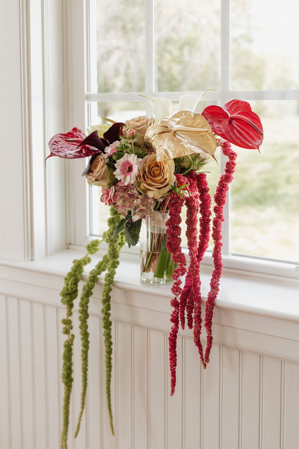 Cascading amaranthus bridal bouquet on a white windowsill at the Callie & Jeremy wedding — designed by Lael Florals