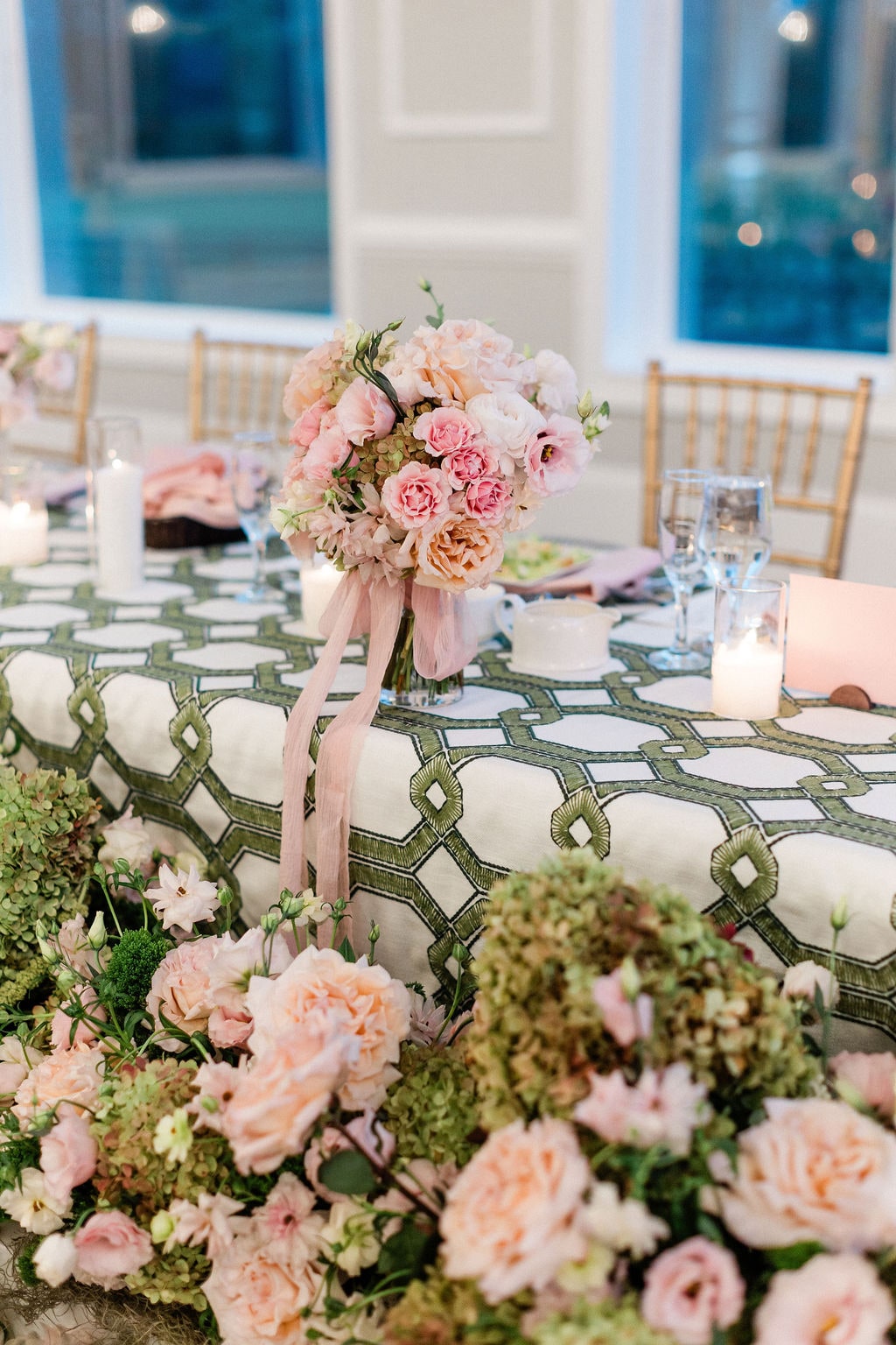 Head table florals up close with a pink ribbon and bud vase, roses, hydrangea and lisianthus, at the Emily & Thomas wedding — designed by Lael Florals