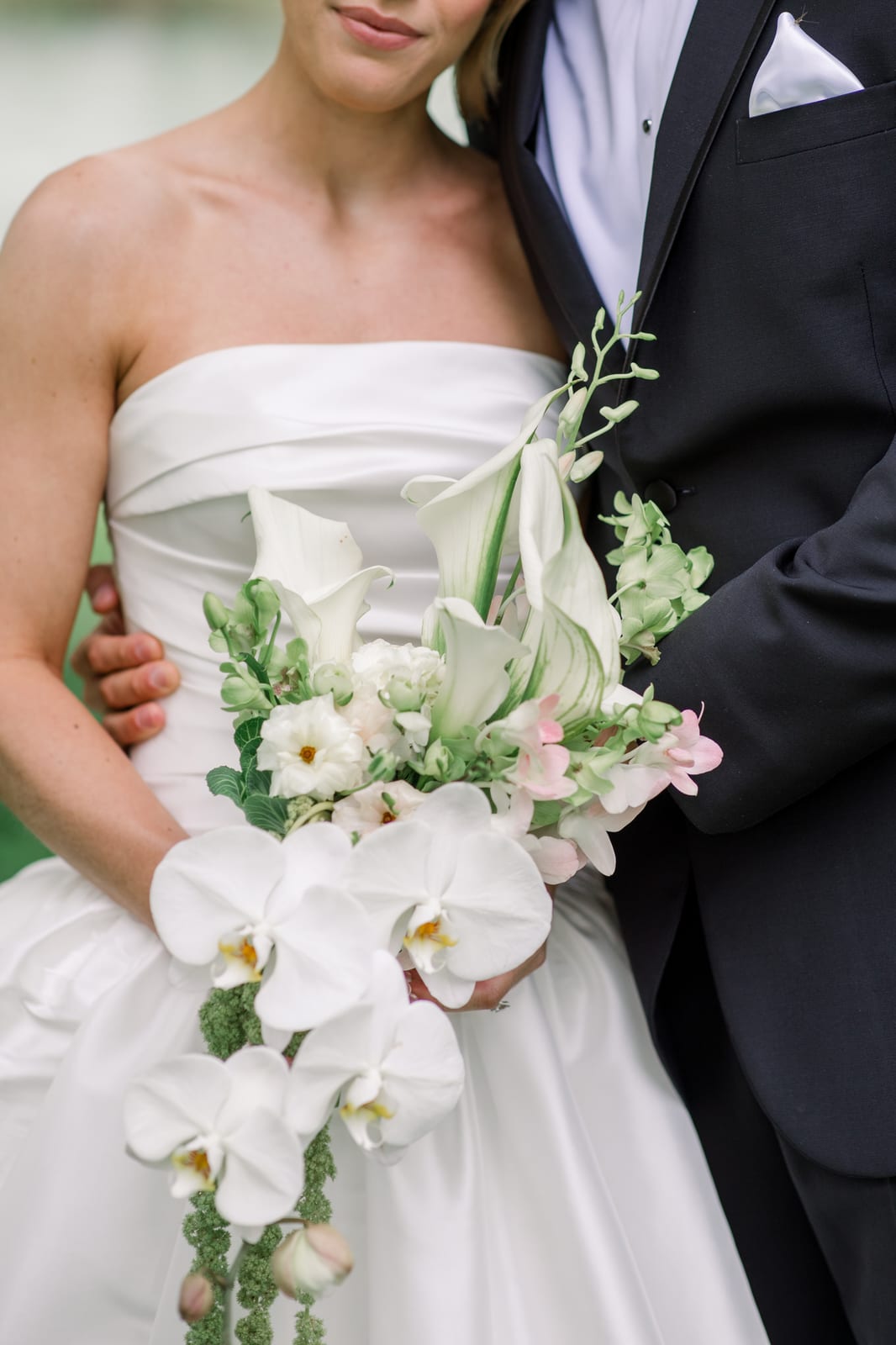Cascading orchid bouquet between the bride and groom at the Gabby & Matt wedding — designed by Lael Florals