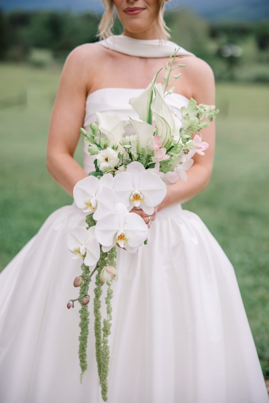 Bride holding a cascading orchid and calla lily bouquet at the Gabby & Matt wedding — designed by Lael Florals