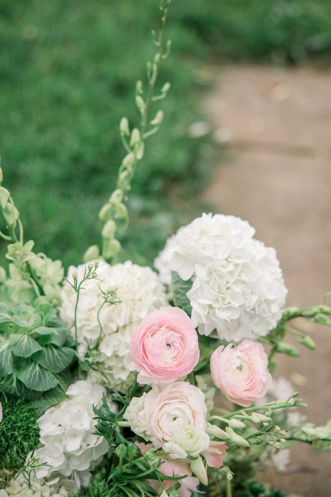 Close-up of blush ranunculus and white hydrangea ceremony arrangement at the Gabby & Matt wedding — designed by Lael Florals