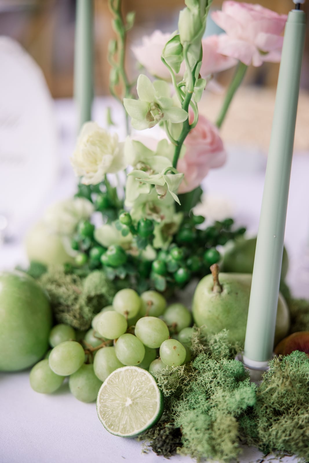 Green grapes, halved lime, and moss centerpiece detail at the Gabby & Matt wedding — designed by Lael Florals