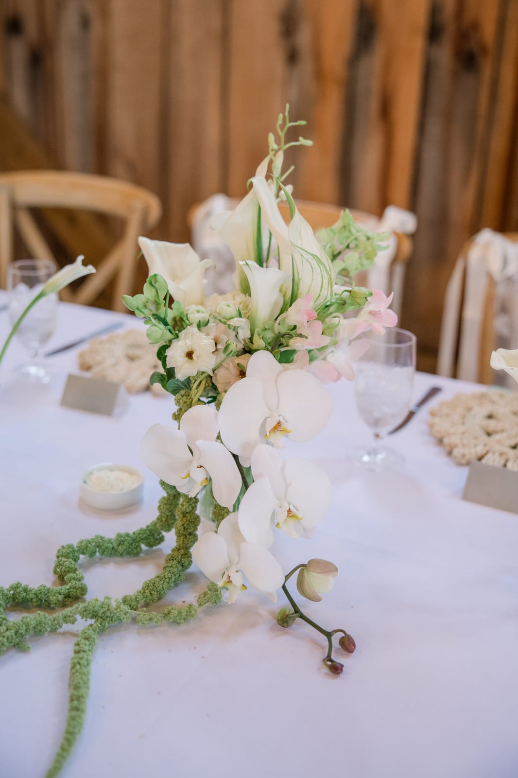 Cascading orchid and amaranthus head table arrangement at the Gabby & Matt wedding — designed by Lael Florals