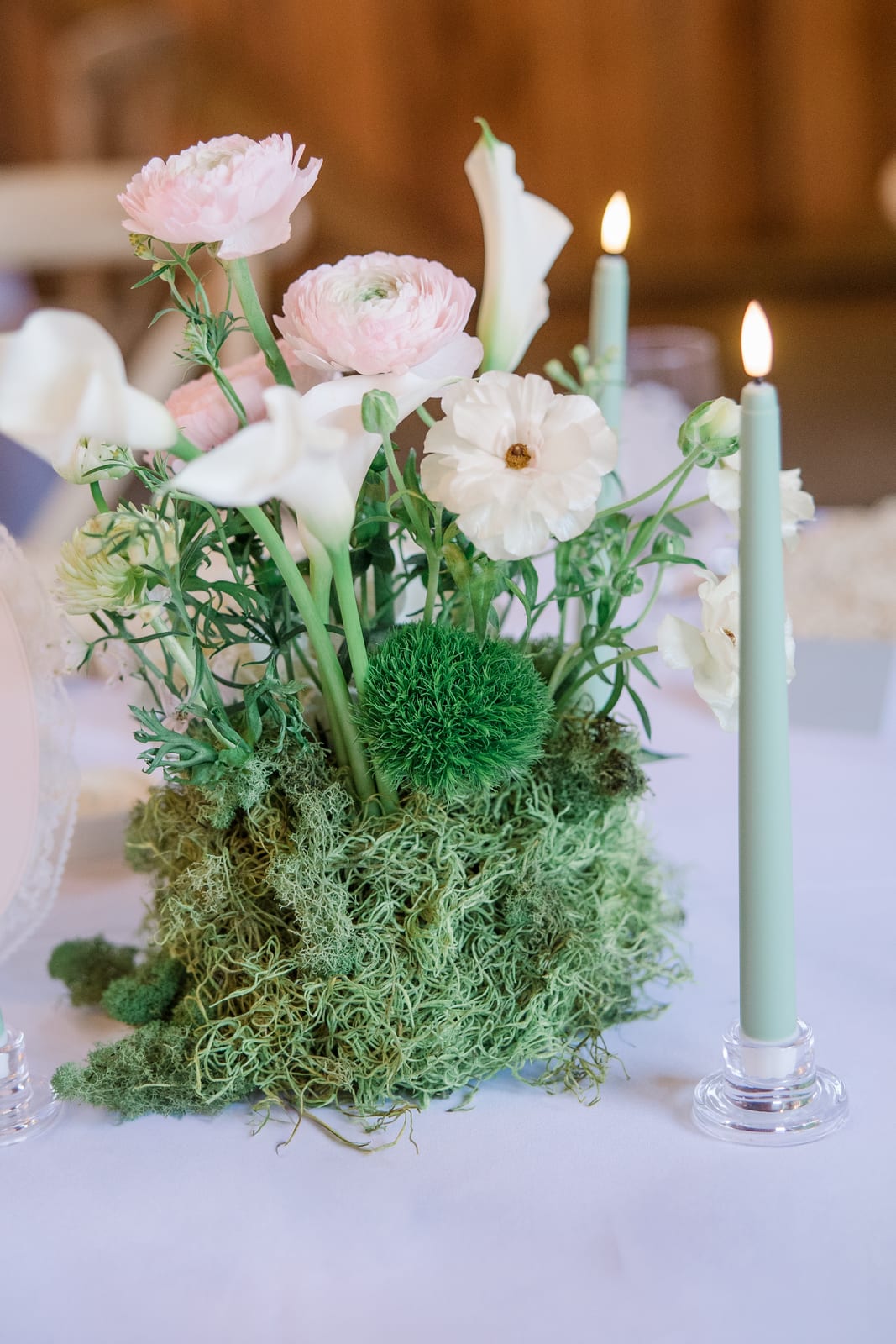 Blush ranunculus and calla centerpiece on a moss base at the Gabby & Matt wedding — designed by Lael Florals