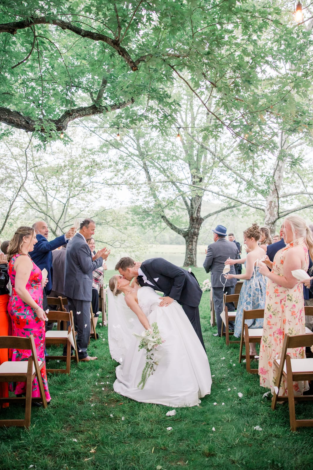 Recessional kiss down the aisle with the bride's trailing bouquet at the Gabby & Matt wedding — designed by Lael Florals
