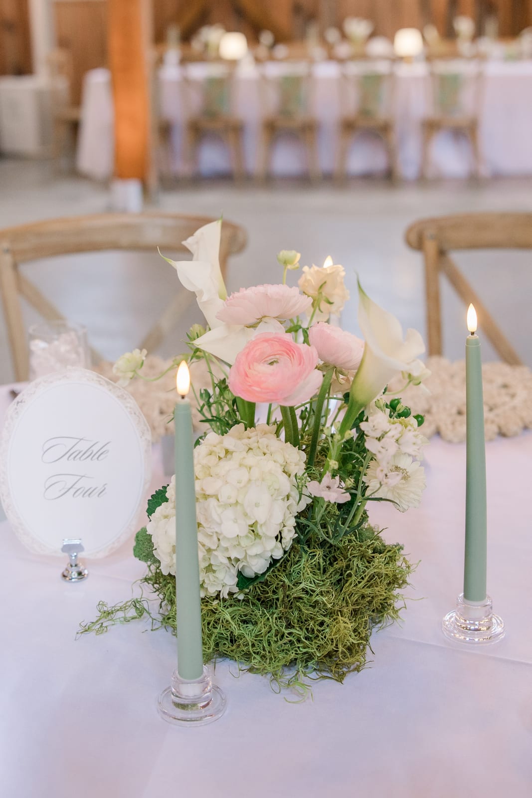 Table Four ranunculus and calla centerpiece with sage tapers at the Gabby & Matt wedding — designed by Lael Florals