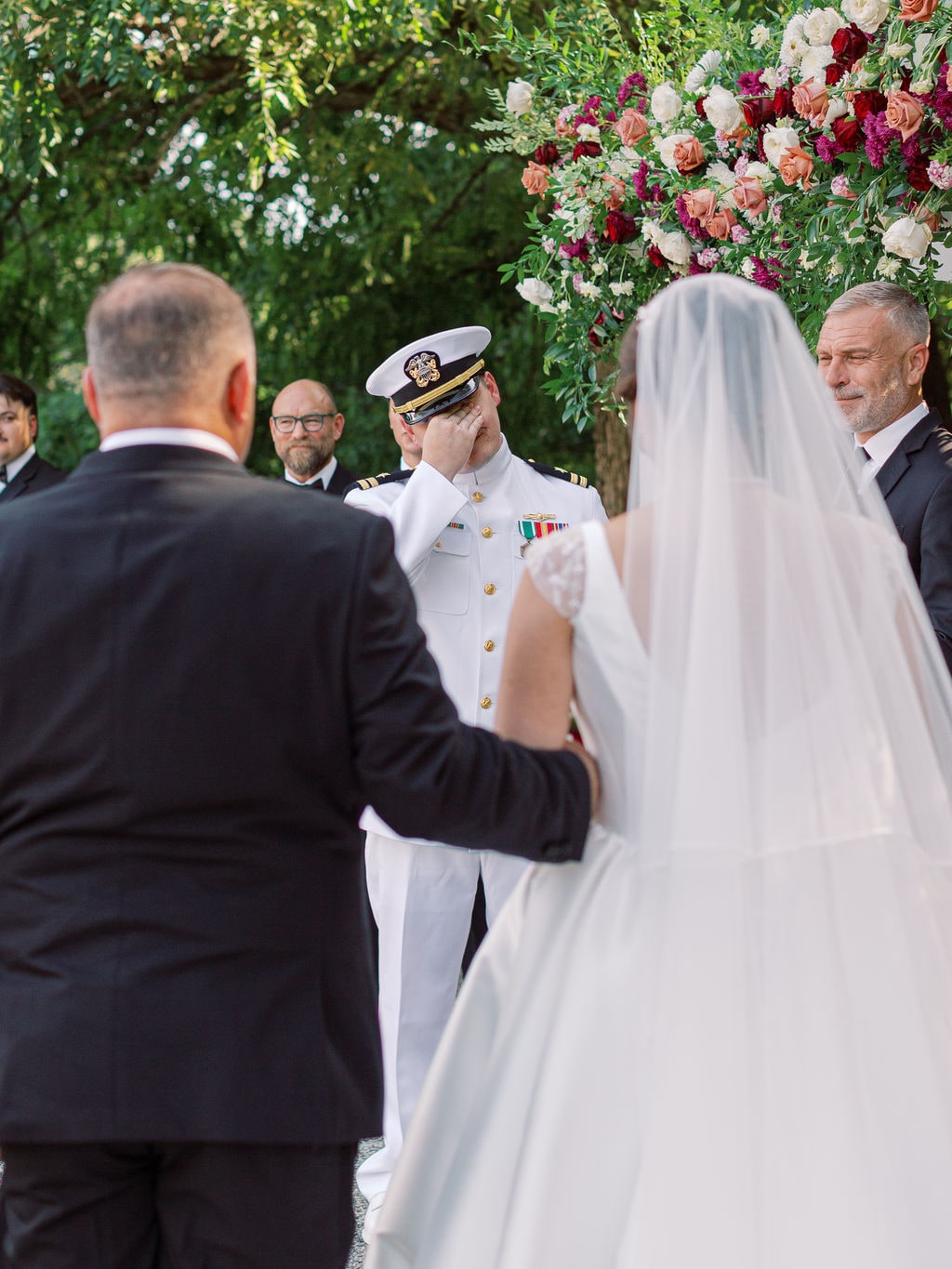 Pergola florals filling the frame above the ring exchange at the Karlie & Hank wedding — designed by Lael Florals