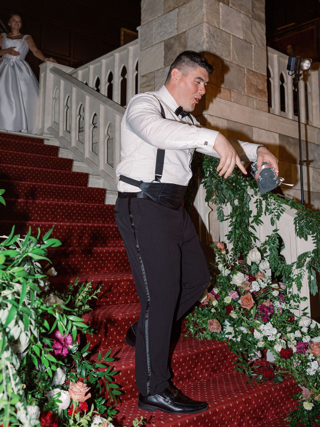Blush and burgundy roses worked into the staircase garland at the Karlie & Hank wedding — designed by Lael Florals