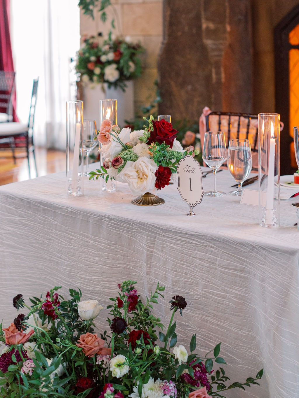 Low runner arrangements and tapers down the head table at the Karlie & Hank wedding — designed by Lael Florals