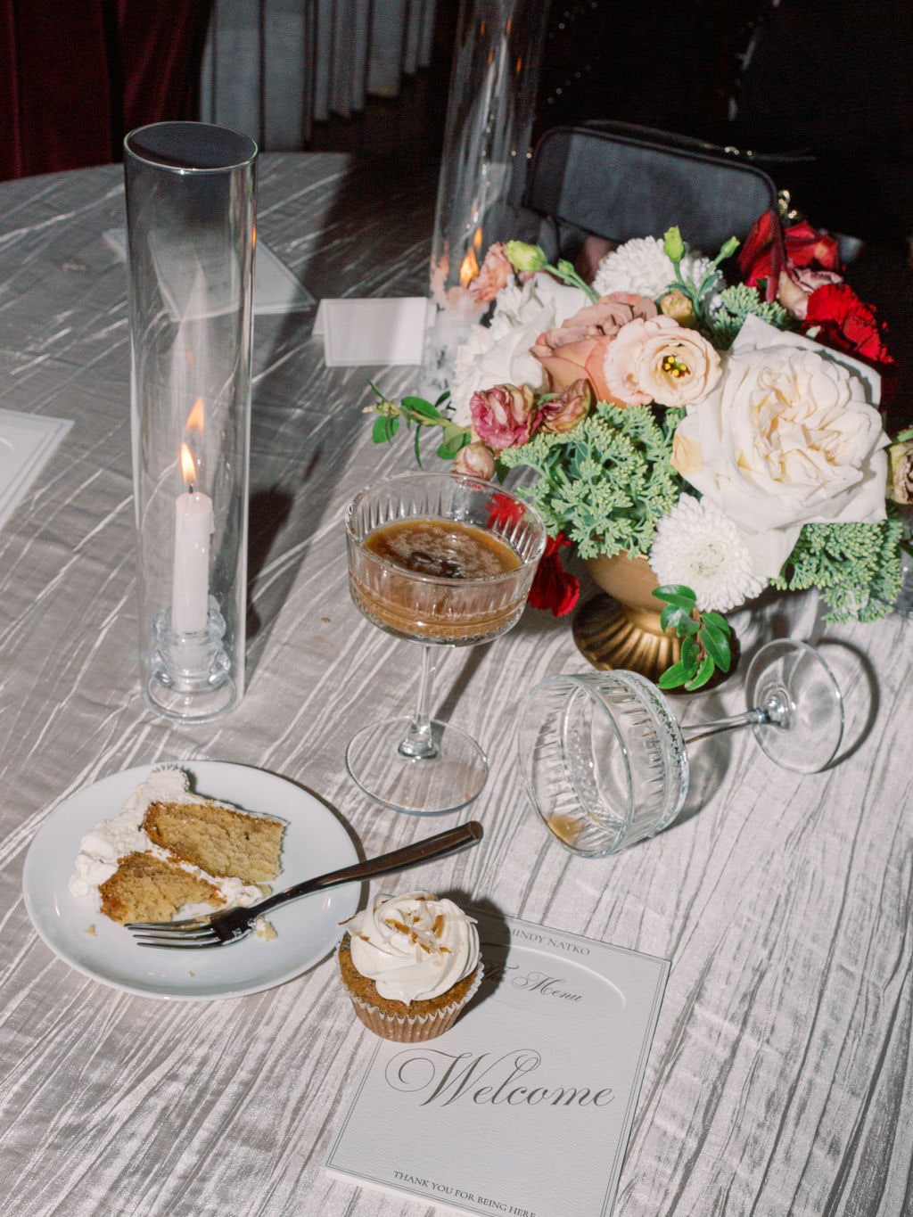 A place setting from above with a compote of garden roses, ranunculus and green hydrangea at the Karlie & Hank wedding — designed by Lael Florals
