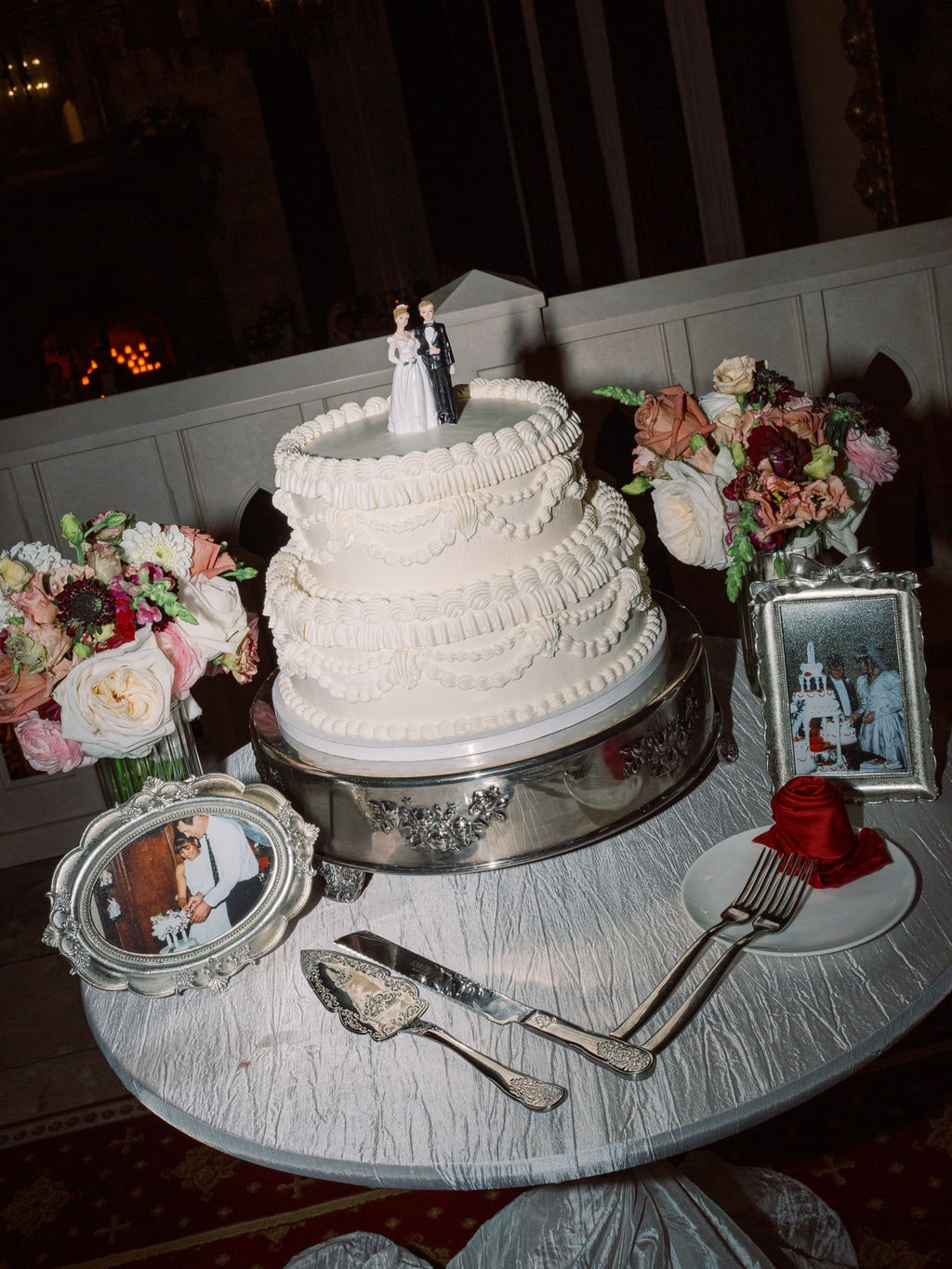 The buttercream cake ringed with floral clusters at the Karlie & Hank wedding — designed by Lael Florals