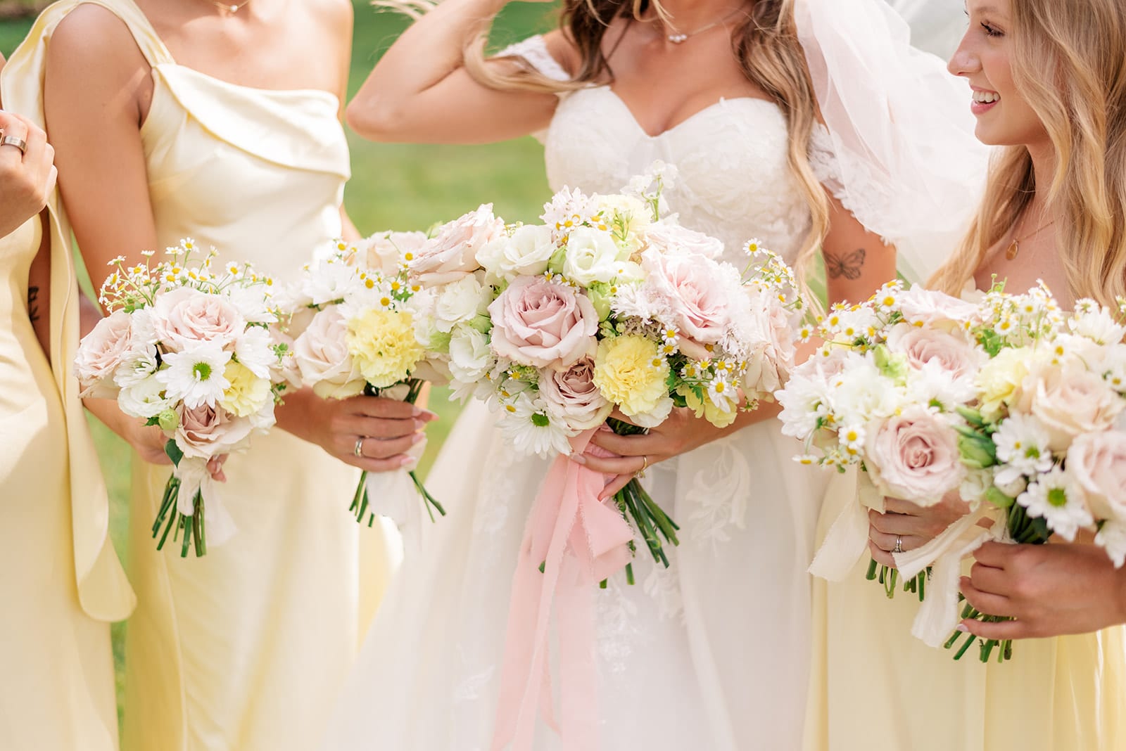 Bridesmaids holding loose garden-style bouquets in blush and cream — designed by Lael Florals