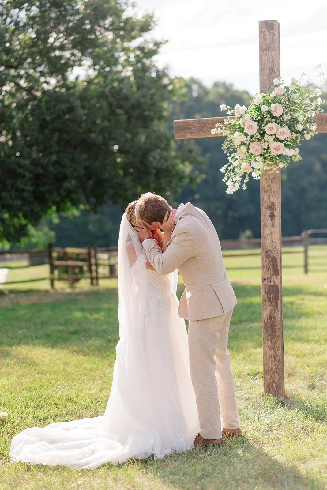 Couple embracing beneath a floral ceremony arch