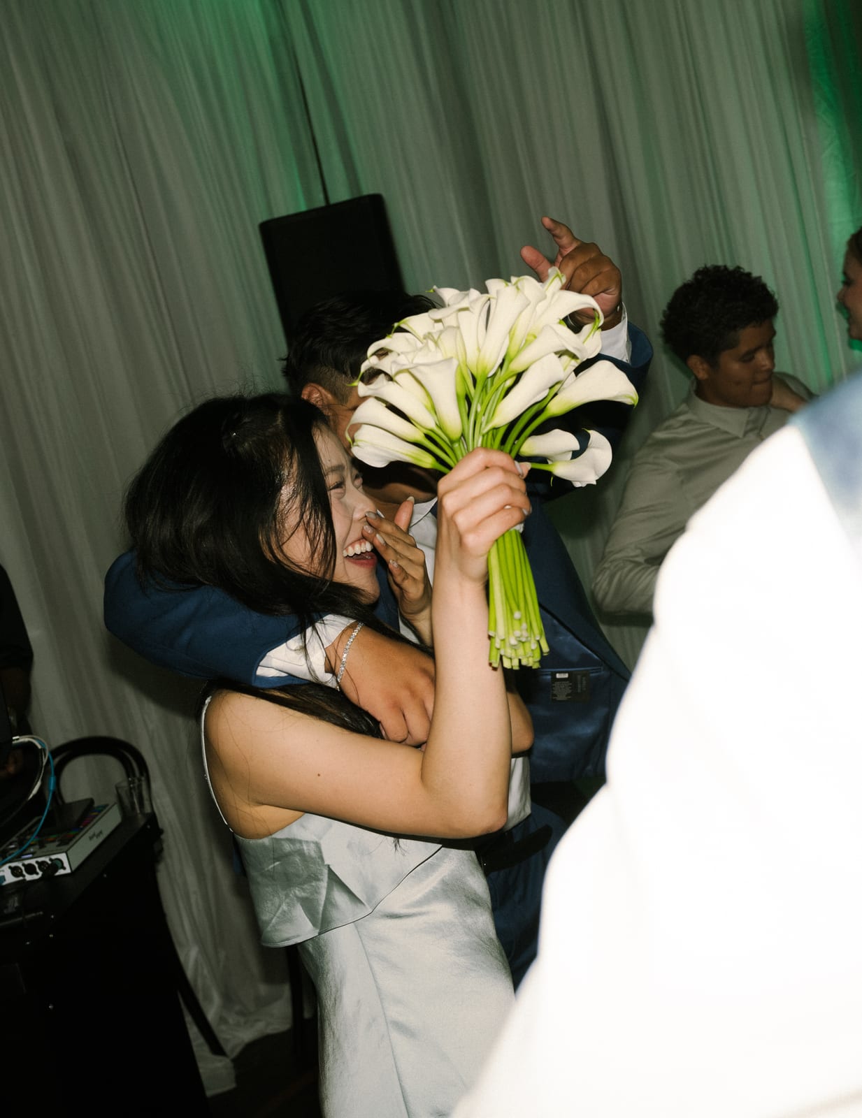 Guest catching the calla lily bouquet on the dance floor at the Sharon & Matt wedding — designed by Lael Florals