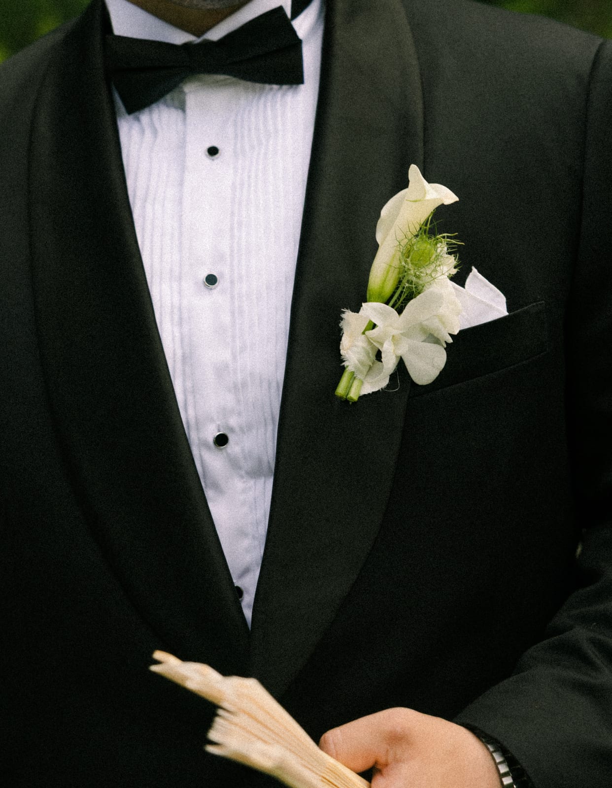 White calla lily boutonniere on a black tuxedo lapel at the Sharon & Matt wedding — designed by Lael Florals