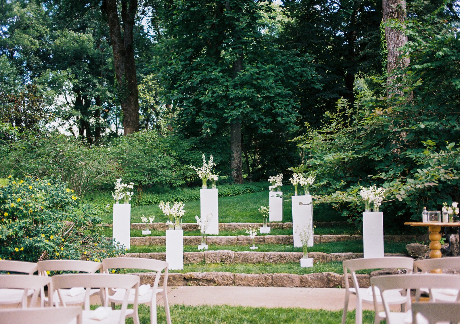 Ceremony amphitheater with pedestal florals and chairs at the Sharon & Matt wedding — designed by Lael Florals