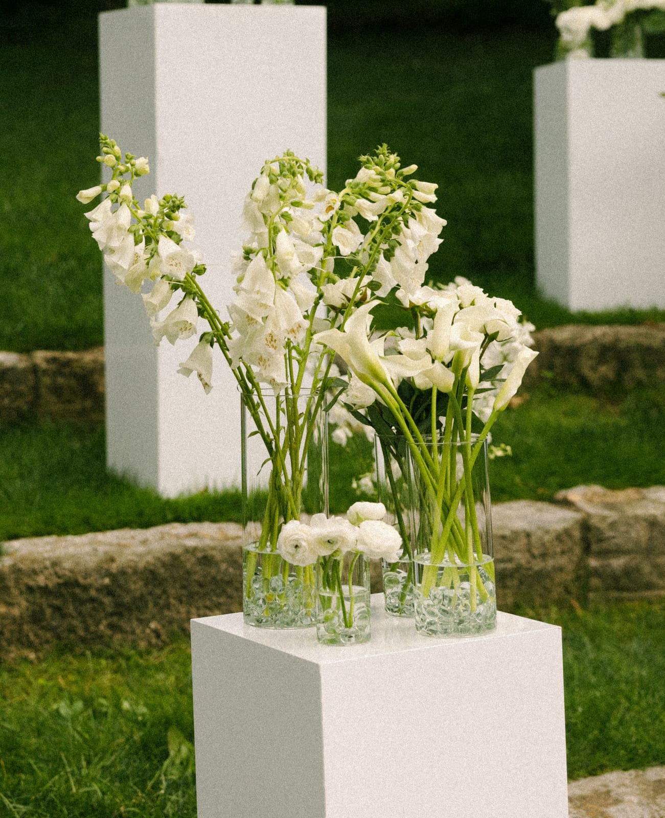 Foxglove and calla lily arrangements on a white pedestal at the Sharon & Matt wedding — designed by Lael Florals